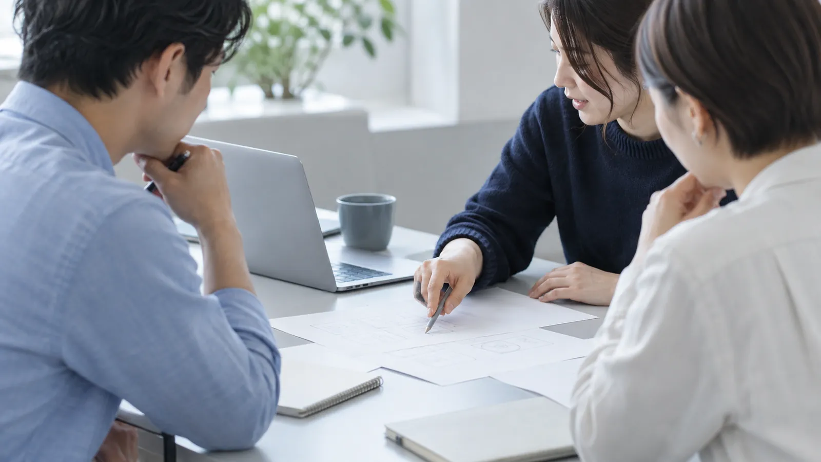 資料を囲み、手元を指し示しながら一緒に考える人々